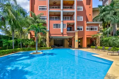 a swimming pool in front of a building at Naxos 15 in Tamarindo