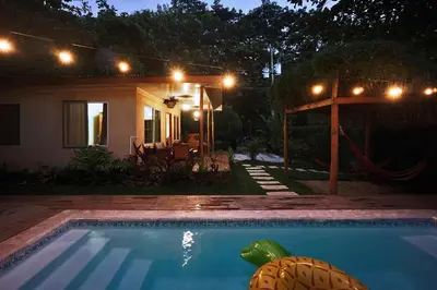 a swimming pool in front of a house at night at Villa Picasso in Santa Teresa Beach