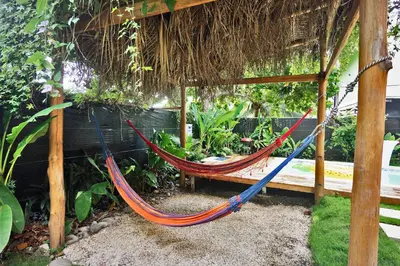 a hammock hanging from a pergola in a garden at Villa Picasso in Santa Teresa Beach