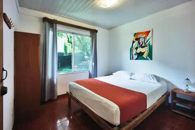 a bedroom with a large bed and a window at Villa Picasso in Santa Teresa Beach