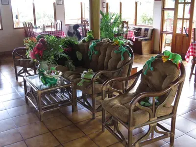 a living room with chairs and a couch and a table at Hotel La Rana de Arenal in Nuevo Arenal