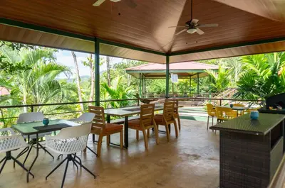a restaurant with tables and chairs and a patio at Arbol Verde Villas in Ojochal