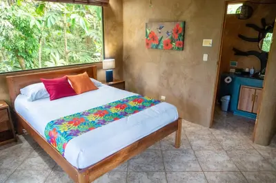 a bed in a room with a large window at Arbol Verde Villas in Ojochal