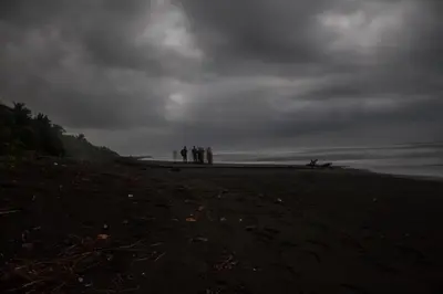 a group of people standing on a beach at Casa Grande at Pacuare Reserve in Matina