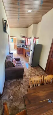 a living room with a couch and a kitchen at Cabina monteverde Soan de Montaña in Monteverde Costa Rica