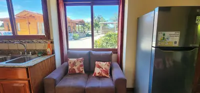 a couch sitting in a kitchen with a window at Cabina monteverde Soan de Montaña in Monteverde Costa Rica