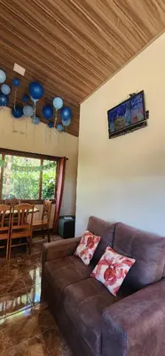 a living room with a brown couch and a table at Cabina monteverde Soan de Montaña in Monteverde Costa Rica