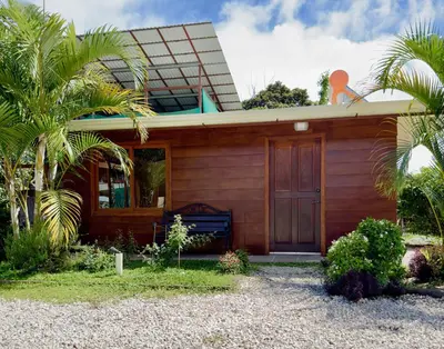 a house with a palm tree in front of it at Cabina monteverde Soan de Montaña in Monteverde Costa Rica
