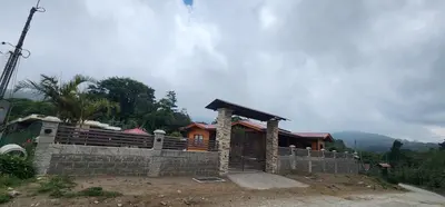 a house on a hill with a stone wall at Cabina monteverde Soan de Montaña in Monteverde Costa Rica
