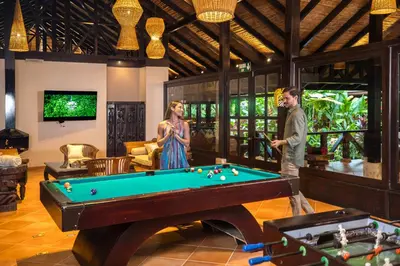a man and a woman standing next to a pool table at Hideaway Rio Celeste Hotel in Bijagua