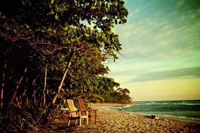 two chairs sitting on a beach near the ocean at Casas Mal Pais in Mal País