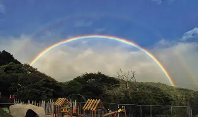 a rainbow in the sky over a playground at Lidia's Mountain View Vacation Homes in Monteverde Costa Rica