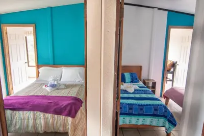a bedroom with a bed and a mirror at Lidia's Mountain View Vacation Homes in Monteverde Costa Rica