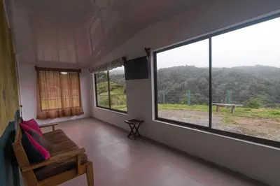 a room with a couch and a large window at Lidia's Mountain View Vacation Homes in Monteverde Costa Rica