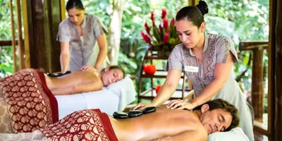 a woman giving a man a massage at Nayara Gardens in Fortuna