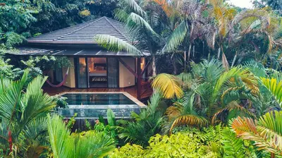 a house with a swimming pool in a garden at Nayara Gardens in Fortuna
