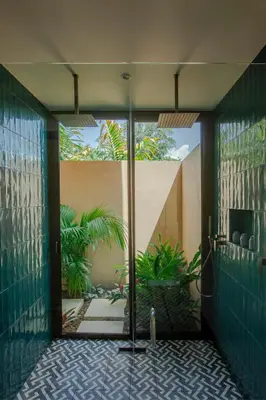 a bathroom with a glass door to a courtyard at Nayara Gardens in Fortuna