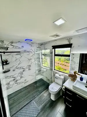 a bathroom with a toilet and a glass shower at Luxury Condo at Jaco Bay, Costa Rica's best beach in Jacó