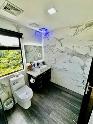 a bathroom with a white toilet and a sink at Luxury Condo at Jaco Bay, Costa Rica's best beach in Jacó