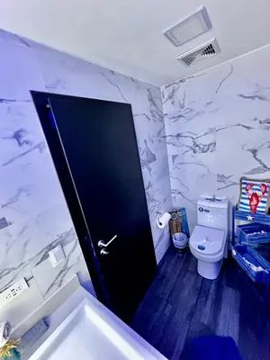 a bathroom with a toilet and a black door at Luxury Condo at Jaco Bay, Costa Rica's best beach in Jacó