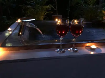 two glasses of wine sitting on a table next to a tub at Arenal Thiago with Private Jacuzzi in Fortuna