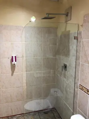 a shower with a glass door in a bathroom at Arenal Thiago with Private Jacuzzi in Fortuna