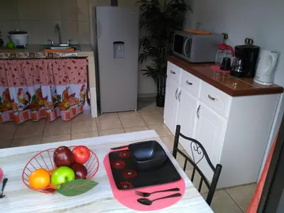 a kitchen with a table with a bowl of fruit on it at Arenal Thiago with Private Jacuzzi in Fortuna