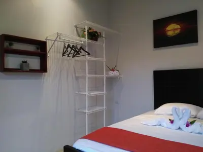 a bedroom with a bed and a white shelf at Arenal Thiago with Private Jacuzzi in Fortuna