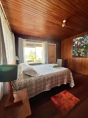a bedroom with a large bed with a window at Apartamento ArteSAna - Jardín de la Diosa in Monteverde Costa Rica