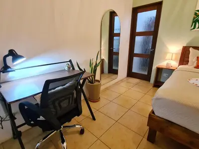 a bedroom with a desk and a bed and a chair at Trebolmar Apartments for remote work in Santa Teresa Beach