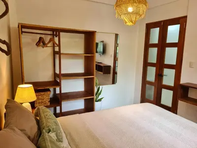 a bedroom with a bed and a mirror and a lamp at Trebolmar Apartments for remote work in Santa Teresa Beach