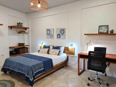 a bedroom with a bed and a desk and a chair at Trebolmar Apartments for remote work in Santa Teresa Beach