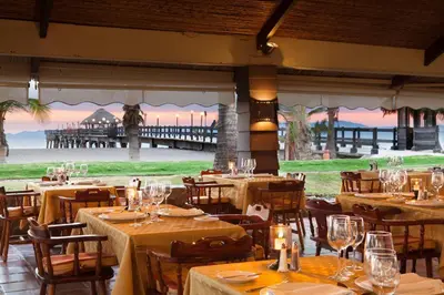 a restaurant with tables and chairs and a pier at Fiesta Resort All Inclusive Central Pacific - Costa Rica in El Roble