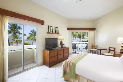 a bedroom with a bed and a television and a balcony at Fiesta Resort All Inclusive Central Pacific - Costa Rica in El Roble