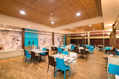 a dining room with tables and blue chairs at Fiesta Resort All Inclusive Central Pacific - Costa Rica in El Roble