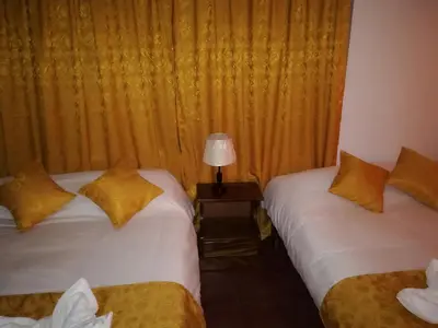 a room with two beds and a lamp on a table at Hotel Don Robert in Puntarenas