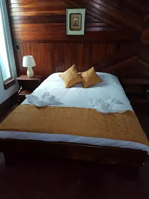 a bed with white sheets and pillows in a room at Hotel Don Robert in Puntarenas