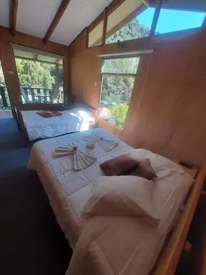 a large bed in a room with two windows at Los Lagos Lodge in San Gerardo de Dota