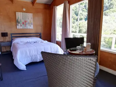 a bedroom with a bed and a table and chairs at Los Lagos Lodge in San Gerardo de Dota