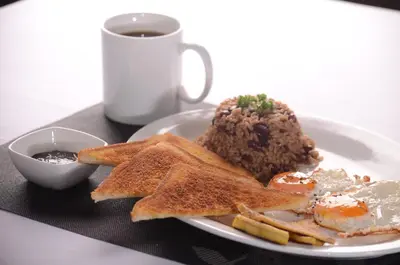 a plate with eggs and toast and a cup of coffee at Los Lagos Lodge in San Gerardo de Dota