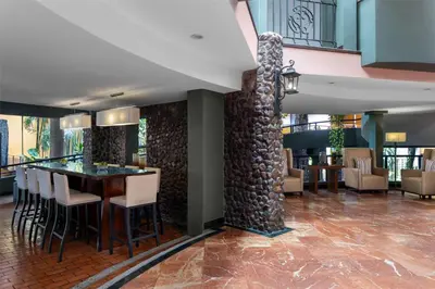 a lobby with a stone pillar and a table and chairs at Hilton Cariari DoubleTree San Jose - Costa Rica in San José