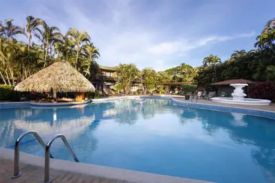 a large swimming pool in a resort with palm trees at Hilton Cariari DoubleTree San Jose - Costa Rica in San José