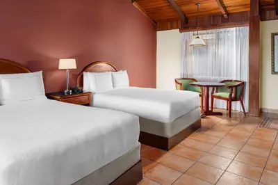 a hotel room with two beds and a table at Hilton Cariari DoubleTree San Jose - Costa Rica in San José