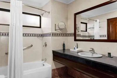 a bathroom with a tub and a sink and a mirror at Hilton Cariari DoubleTree San Jose - Costa Rica in San José