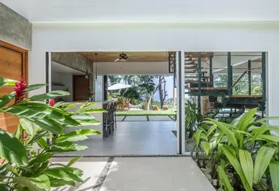 an open door to a tropical house with plants at Villa Makai Santa Teresa in Santa Teresa Beach