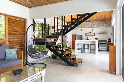a living room with a spiral staircase in a house at Villa Makai Santa Teresa in Santa Teresa Beach