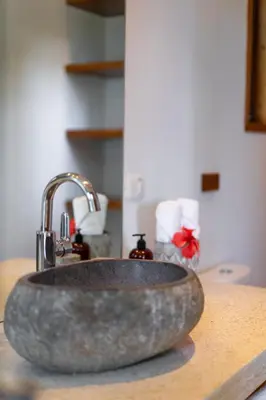 a bathroom sink with a granite counter top at Villa Makai Santa Teresa in Santa Teresa Beach