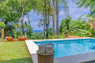 a swimming pool with a view of the ocean at Villa Makai Santa Teresa in Santa Teresa Beach