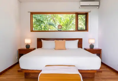 a bedroom with a large white bed with a window at Villa Makai Santa Teresa in Santa Teresa Beach