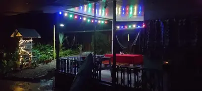 a patio with a table and colorful lights on it at Cabins yafeth osa drake bay in Drake